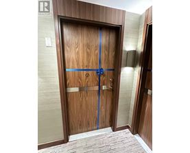A wooden door with a blue tape across it.