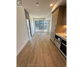 A kitchen with wooden floors and a stainless steel oven.