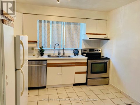 A kitchen with white cabinets and a stainless steel refrigerator.
