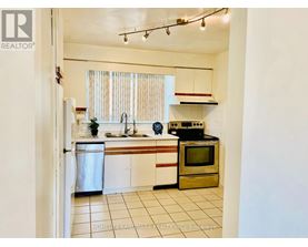 A kitchen with white cabinets and a stainless steel refrigerator.