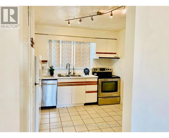 A kitchen with white cabinets and a stainless steel refrigerator.