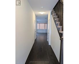 A hallway with a staircase on the right side.