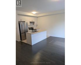 A kitchen with a refrigerator, stove, and oven.