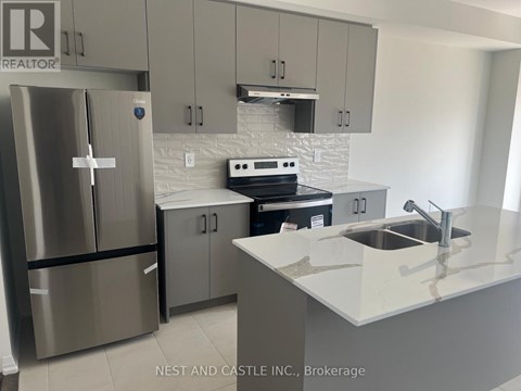 A kitchen with a stainless steel refrigerator and a white countertop.