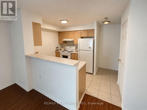 A kitchen with white appliances and wooden cabinets.