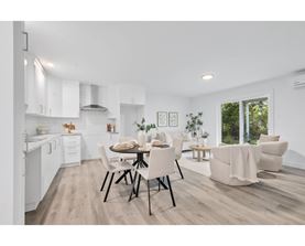 A modern kitchen with a dining table set for two.