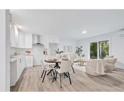 A modern kitchen with a dining table set for two.