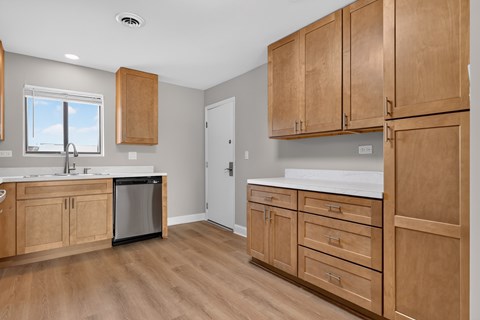 A kitchen with wooden cabinets and a white countertop.