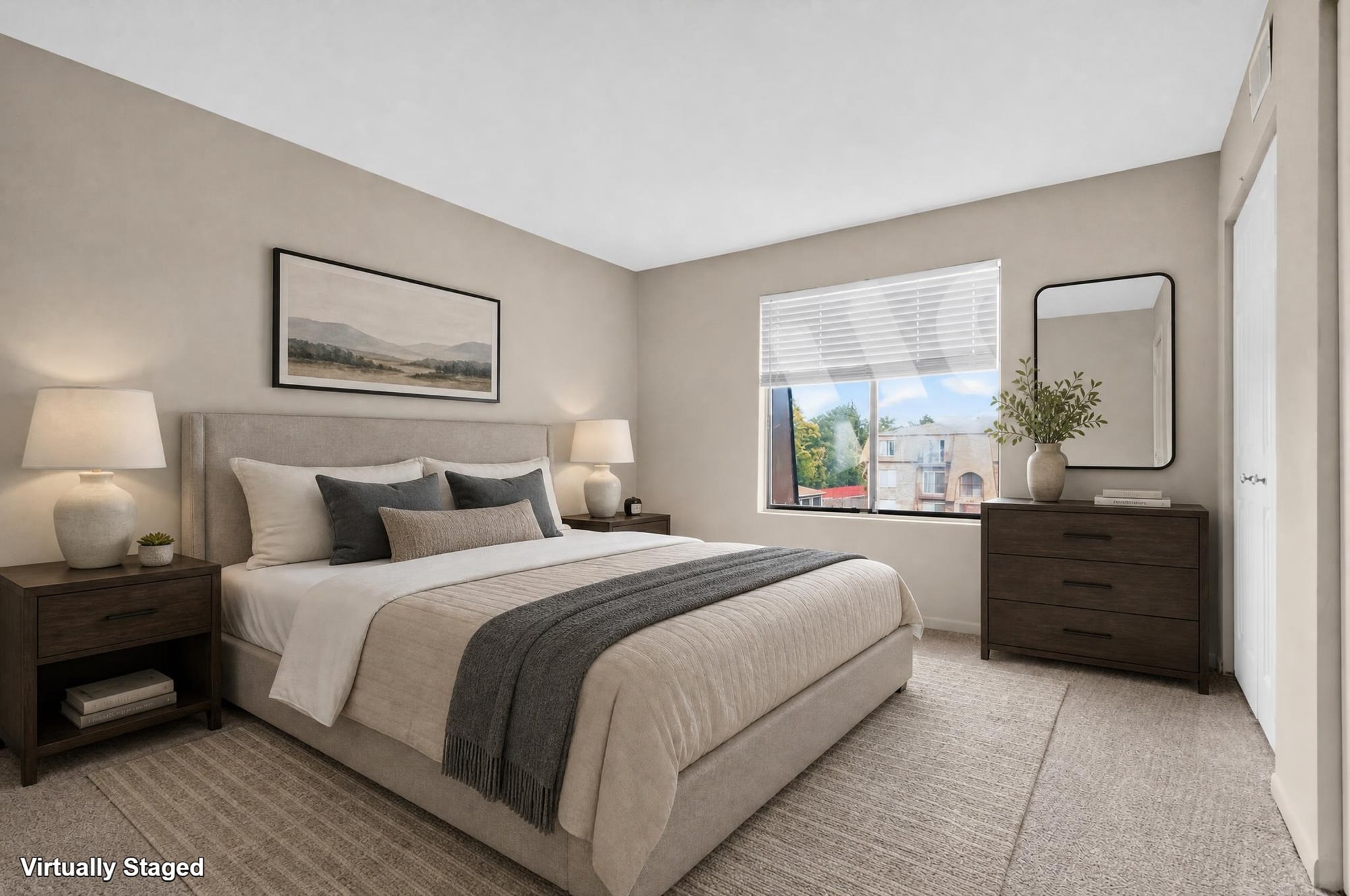 A bedroom with a large bed, two nightstands, and a window overlooking a cityscape.