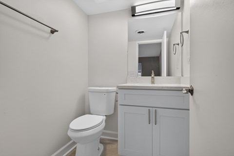 A white toilet sits next to a sink in a small bathroom.
