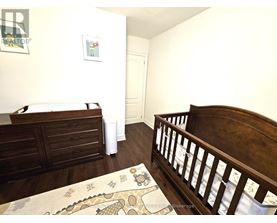 A bedroom with a wooden bed and a rug with a dinosaur design.