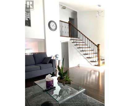 A living room with a grey couch and a glass coffee table.