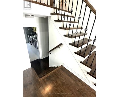 A staircase with a black railing and wooden steps.