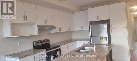 A kitchen with white cabinets and a granite countertop.