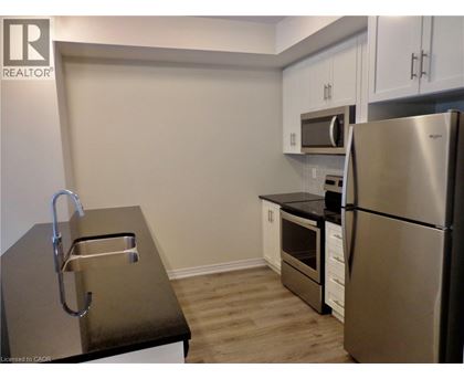 A kitchen with a refrigerator, sink, and oven.