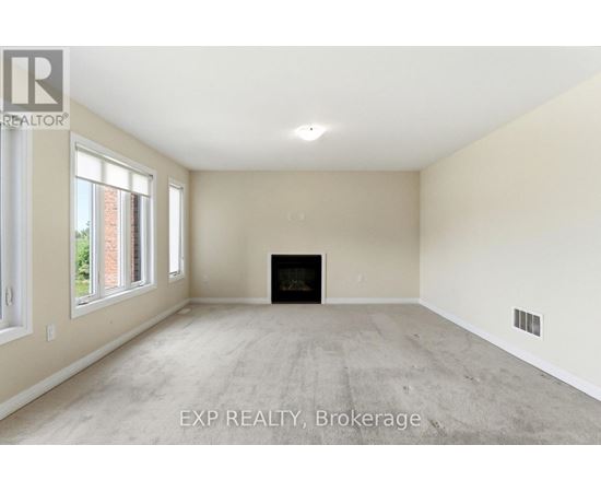 A spacious living room with a fireplace and large windows.