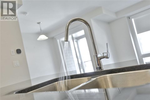 A modern kitchen sink with a faucet and running water.