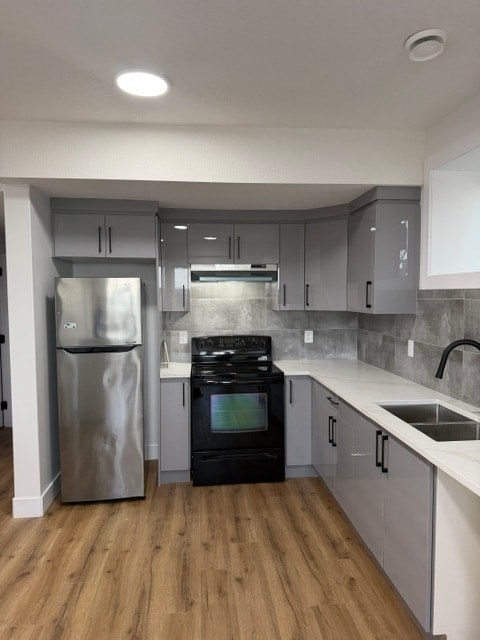 A kitchen with a black oven and a stainless steel refrigerator.