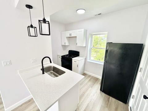 A kitchen with black appliances and white cabinets.