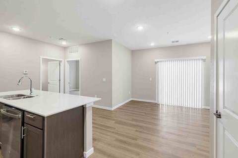 A kitchen with a white countertop and wooden flooring.