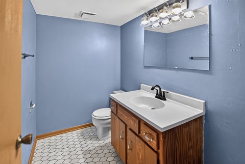 A bathroom with blue walls and a white sink.