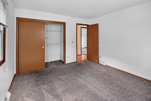 A room with two doors and a carpeted floor.