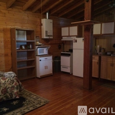 A kitchen with wooden floors and white appliances.