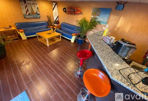 A living room with a blue couch and a wooden floor.