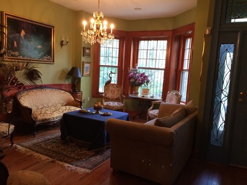 A living room with a couch, chair, and a table with a vase of flowers on it.