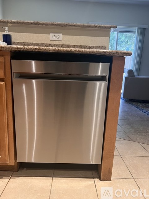A stainless steel dishwasher is built into a kitchen counter.