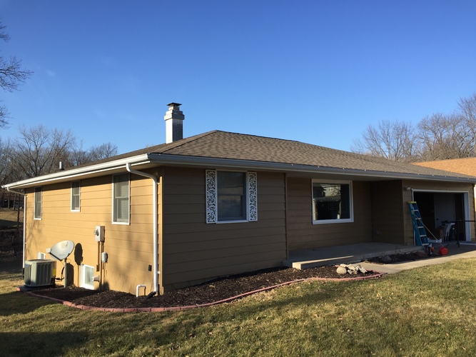 A house with a brown roof and a satellite dish on the left side.