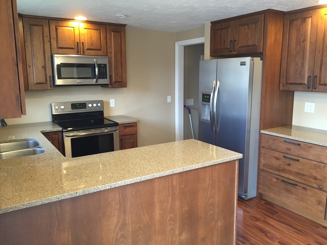 A kitchen with wooden cabinets and a granite countertop.