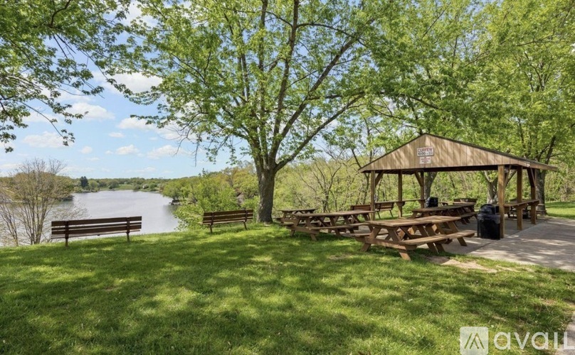 A gazebo sits in a grassy area next to a river.