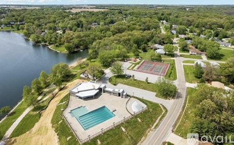 An aerial view of a house with a swimming pool and tennis court.