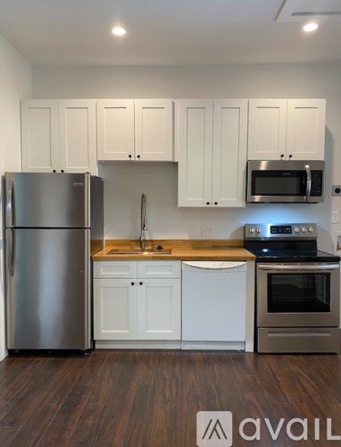 A kitchen with white cabinets and a stainless steel refrigerator.