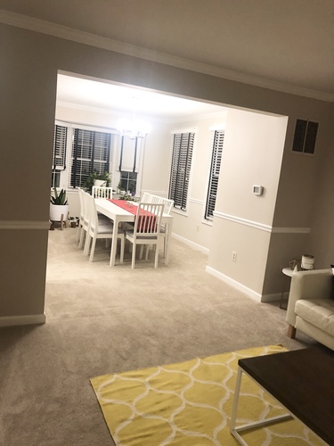 A dining room with a table and chairs.