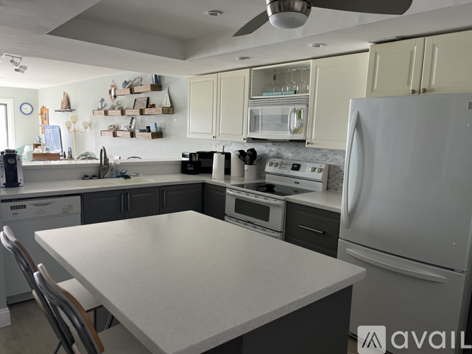 A kitchen with a white table and a refrigerator.
