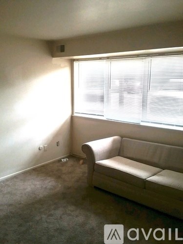 A living room with a couch and a window.