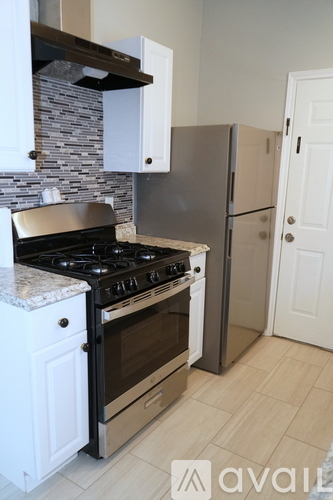 A kitchen with a black stove top oven and a silver oven built into the wall.
