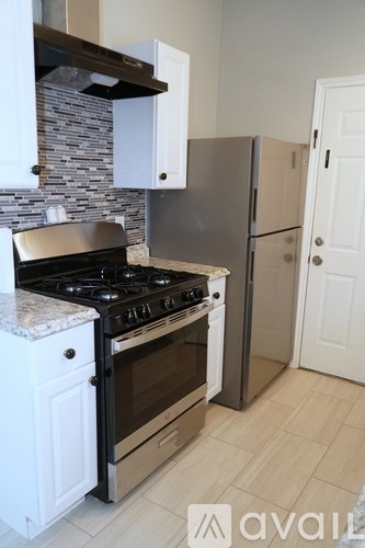 A kitchen with a black stove top oven and a silver oven built into the wall.