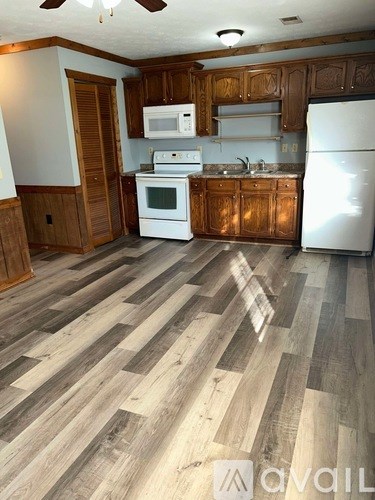 A kitchen with wooden cabinets and a white fridge.
