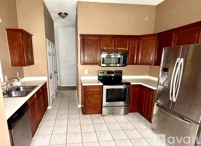 A kitchen with wooden cabinets and a stainless steel refrigerator.