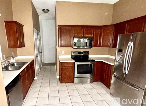 A kitchen with wooden cabinets and a stainless steel refrigerator.