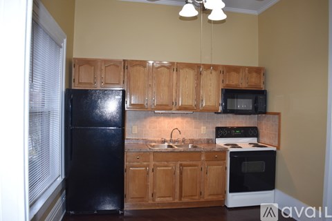 A kitchen with wooden cabinets and black appliances.