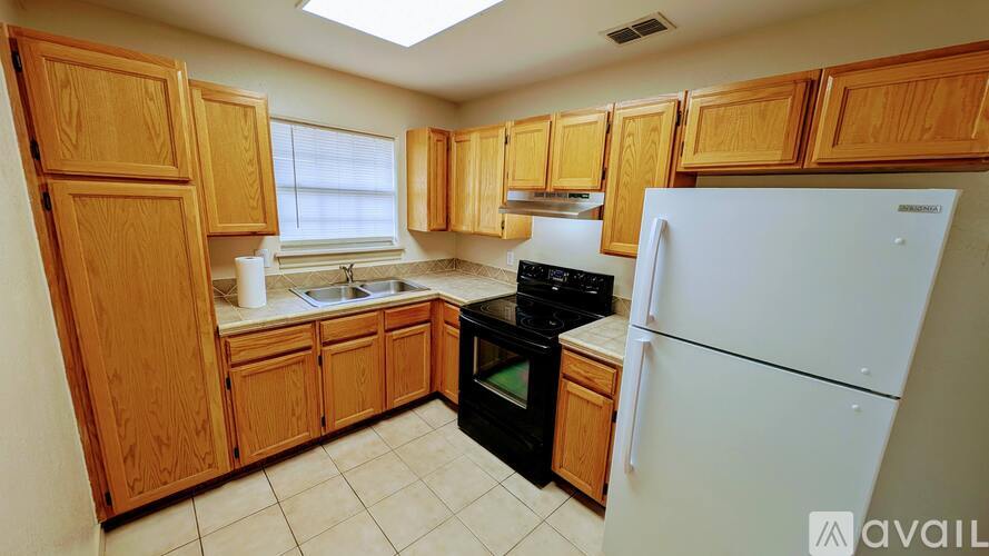 A kitchen with wooden cabinets and a white refrigerator.