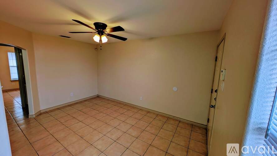 A room with a ceiling fan and tile flooring.