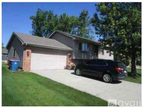 A black car is parked in front of a house.