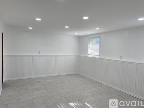 A spacious room with a window and a tiled floor.