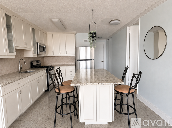 A kitchen with white cabinets and a granite countertop.