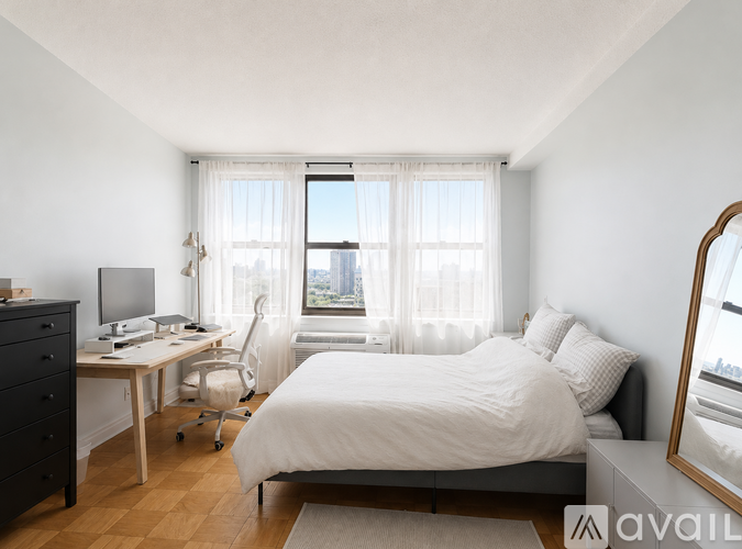 A bedroom with a bed, desk, and chair.